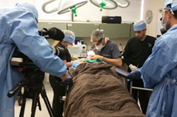 Dr. Epstein siendo filmado por una cadena de noticias de la televisión nacional realizando un trasplante de barba y pelo torácico