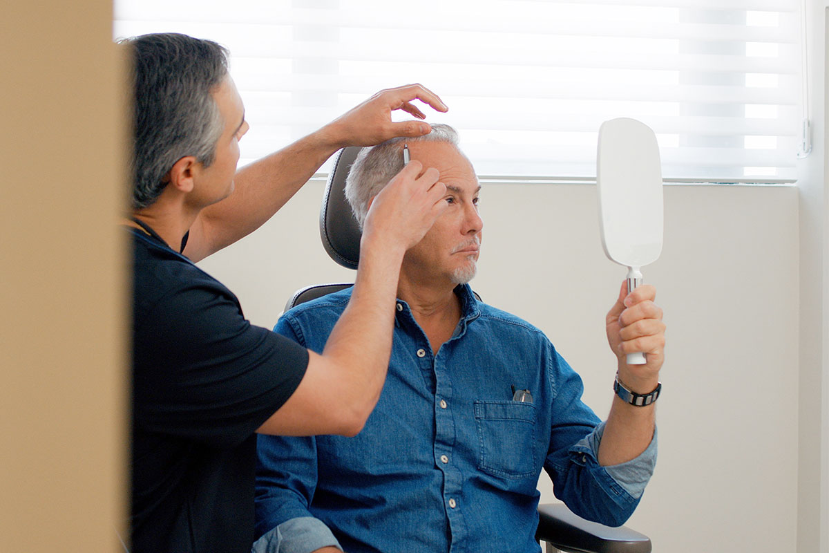 older male patient and Miami hair loss specialist doctor in a medical office